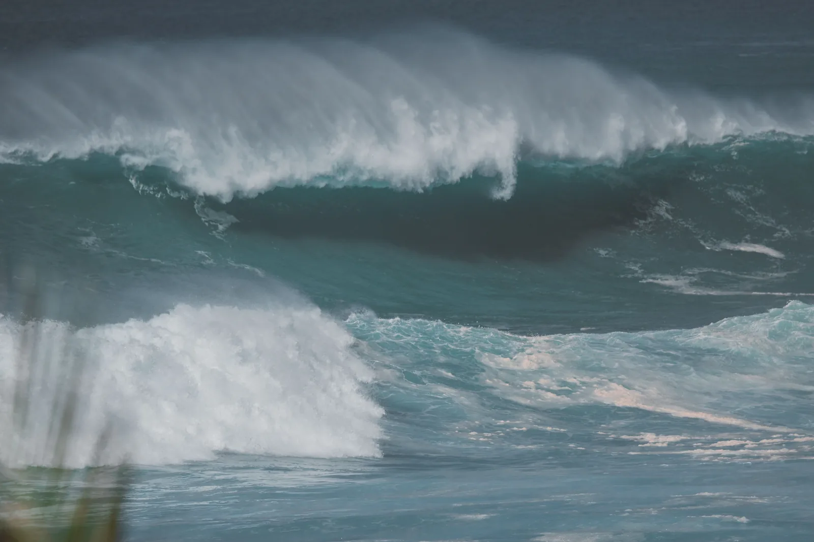 Large stormy ocean waves churning and breaking along the rugged volcanic shoreline of Hawaii