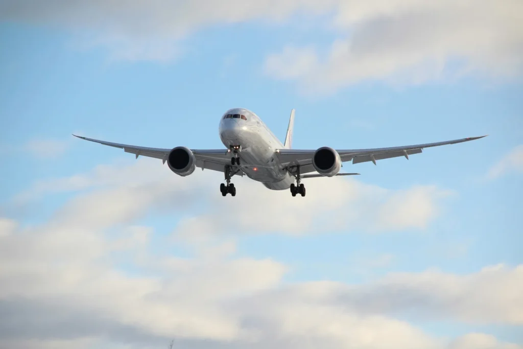 A widebody commercial airliner flying at cruising altitude under a clear blue sky